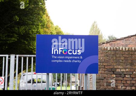 I problemi visivi e i complessi di InFocus necessitano di cartellonistica blu con alberi sullo sfondo Foto Stock