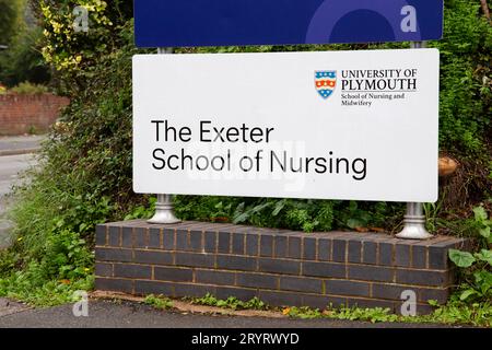 Primo piano della segnaletica della Exeter School of Nursing sull'ingresso laterale con autobus verdi ottobre 2023 Foto Stock