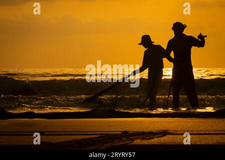 Fujairah, Emirati Arabi Uniti - 10 ottobre 2014: Pescatori con il loro pescato sulla spiaggia di Fujairah negli Emirati Arabi Uniti. Foto Stock