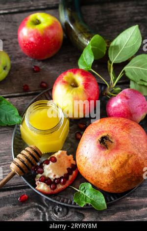 Immagine religiosa del concetto di Rosh hashanah (festività ebraica di Capodanno). Simboli tradizionali: Miele, mele e melograno su un buio Foto Stock
