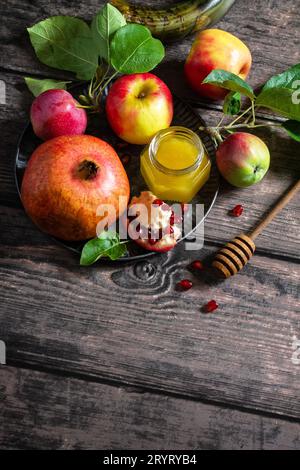 Immagine religiosa del concetto di Rosh hashanah (festività ebraica di Capodanno). Simboli tradizionali: Miele, mele e melograno su un buio Foto Stock