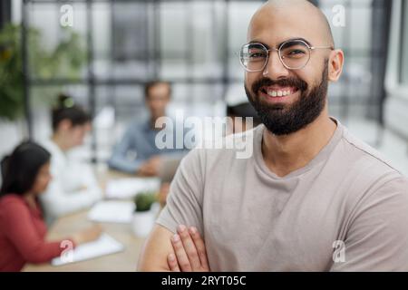 Ritratto di un uomo d'affari maturo sicuro di sé in piedi con le braccia incrociate in un ufficio. Foto Stock