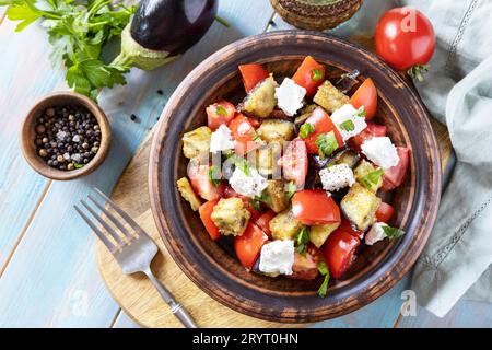 Dieta sana basso carb. Insalata con melanzane alla griglia, pomodori e formaggio feta su un tavolo di legno rustico. Vista dall'alto. Foto Stock