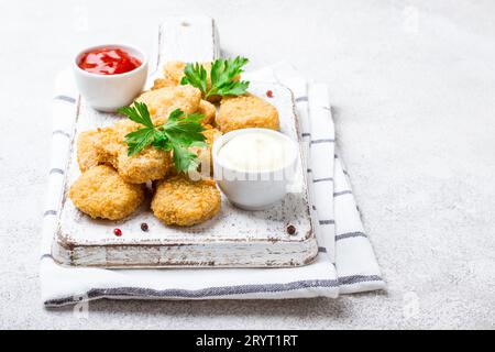 Pepite di pollo croccanti fritte con salse popolari Foto Stock