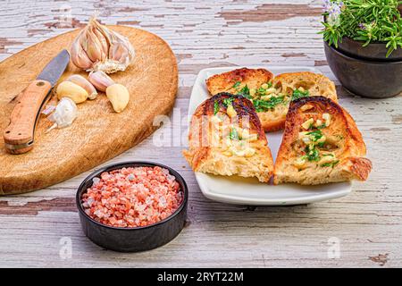 Un tagliere di legno con una varietà di ingredienti, tra cui il pane, sistemato su di esso. Foto Stock