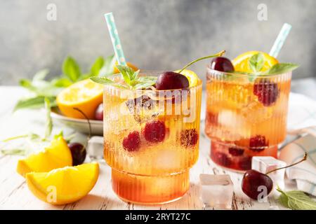 Bevanda rinfrescante ghiacciata limonata di cola di ciliegio d'arancia o cocktail di mojito in vetro su un tavolo di legno. Drink estivo fresco. Foto Stock