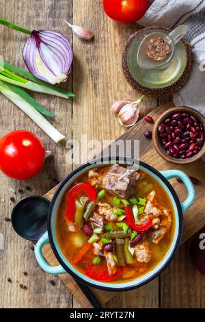 Tradizionale zuppa inglese spessa con manzo, fagioli e verdure su un tavolo di legno. Cena calda o pranzo. Vista dall'alto, disposizione piatta. Foto Stock