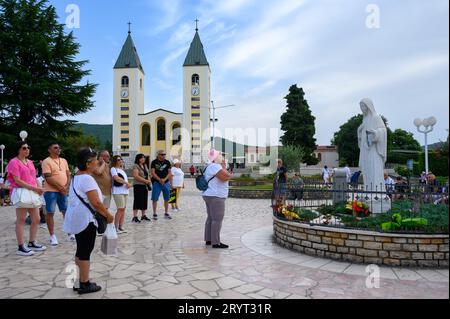 La gente prega intorno alla statua della Regina della Pace vicino alla Chiesa di San Giacomo a Medjugorje, Bosnia-Erzegovina. Foto Stock