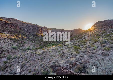 Da un punto di vista elevato è possibile ammirare una vista mozzafiato del tramonto su un paesaggio montano Foto Stock