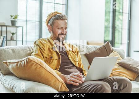 Happy client guarda il risultato del lavoro di freelance sul computer. Uomo con attenzione concentrata, vede il risultato del libero professionista Foto Stock