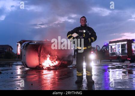 Ritratto di un eroico vigile del fuoco in una tuta protettiva. Vigile del fuoco in operazioni antincendio. Foto Stock