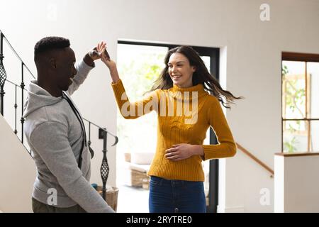 Coppia felice e variegata che balla in sala a casa Foto Stock