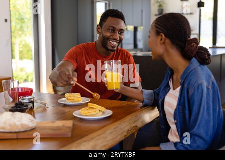 Felice coppia afro-americana che gusta la colazione nella sala da pranzo Foto Stock