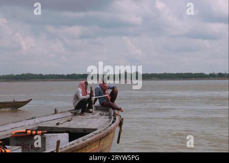 2 uomini su una barca nel fiume Gange a Varanasi. Foto Stock