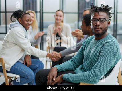 Ha riunito giovani uomini d'affari felici che hanno condotto i negoziati, incontrandosi con i colleghi differenti ed amichevoli Foto Stock
