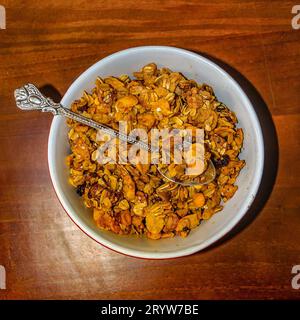 Vista dall'alto mix di cereali e noci su piastra bianca e su un tavolo di legno Foto Stock