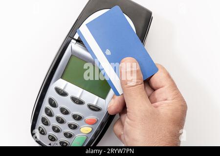 Effettua il pagamento a mano con carta di credito con tecnologia NFC contactless sul dispositivo terminale. Sfondo bianco Foto Stock