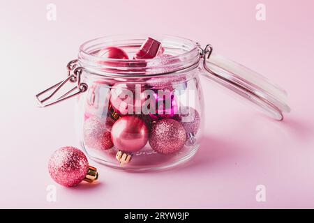 Piccole palline di Natale rosa in un vaso di vetro Foto Stock