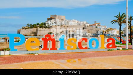 Peniscola, Spagna - 15 settembre 2023: Una vista dell'insegna colorata con il nome della città, sulla spiaggia di Norte a Peniscola, Spagna, con la città vecchia Foto Stock