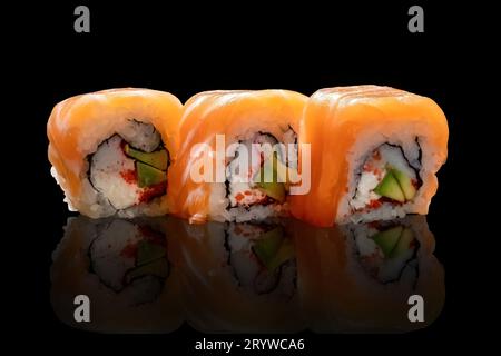 tre pezzi di sushi su una superficie nera riflettente. Cucina asiatica. Foto Stock