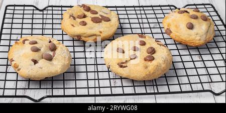 Biscotti con gocce di cioccolato su griglia metallica su un tavolo in marmo. Foto Stock