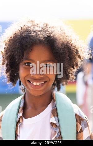 Ritratto verticale del sorridente studente afroamericano elementare nel parco giochi scolastico, spazio fotocopie Foto Stock