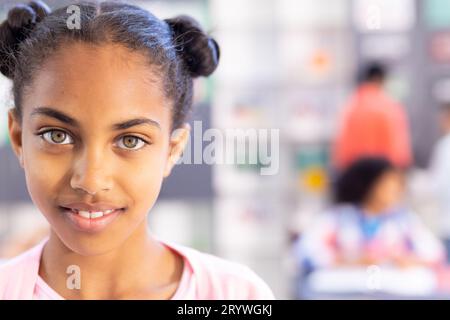 Ritratto di una studentessa birazziale sorridente in classe con spazio fotocopie Foto Stock