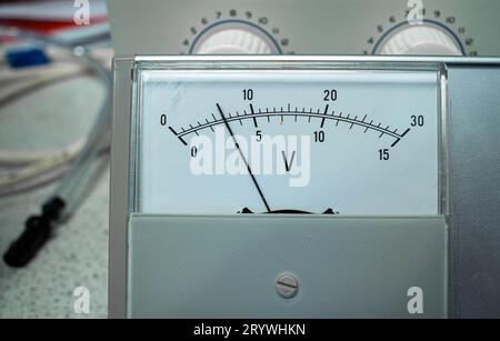 Vista dettagliata del pannello di visualizzazione di un voltmetro analogico per l'uso in ambito scientifico o didattico. Foto Stock