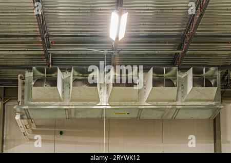 Un ventilatore per evaporatore di refrigerazione industriale a cinque ventole in un magazzino di stoccaggio a freddo con ciclo di ammoniaca. Foto Stock