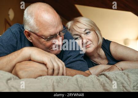 Ritratto di una coppia anziana sposata che si trova sul letto. Foto Stock