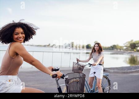 Adolescenti di diverse nazionalità e aspetto in bicicletta percorrono una strada cittadina Foto Stock