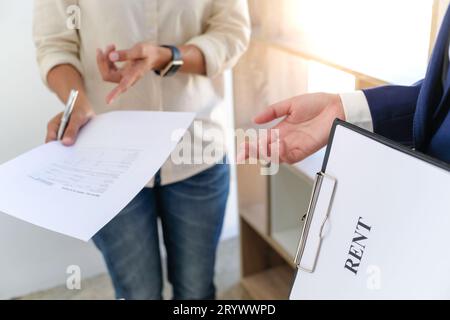 Responsabile delle vendite che dà il documento di modulo di richiesta di consiglio, considerando l'offerta di prestito ipotecario per l'assicurazione dell'automobile e della casa. Foto Stock