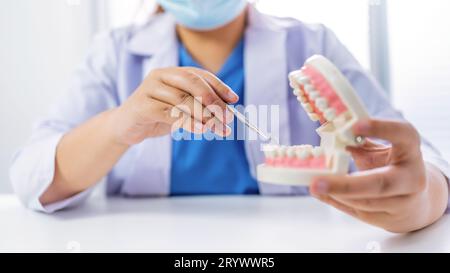 Dentista presso la clinica odontoiatrica White dente sano con modello dentale in chirurghi orali che discutono la radiografia della mascella sulla medicina tabletÂ sano Foto Stock