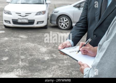 Agente assicurativo del registro delle perdite che ispeziona la vettura danneggiata. Il responsabile delle vendite fornisce un documento di richiesta di consulenza che valuta l'offerta di mutui ipotecari per l'acquisto di autoveicoli Foto Stock