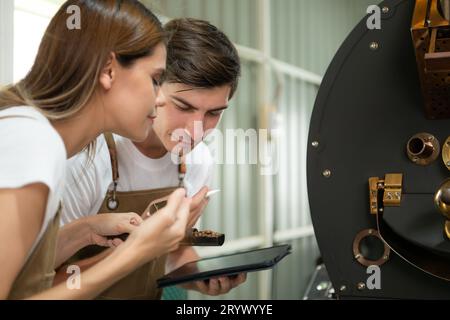 Sia della torrefazione che della macchina per torrefazione, controlla la qualità della torrefazione nell'impianto di torrefazione del caffè. Foto Stock