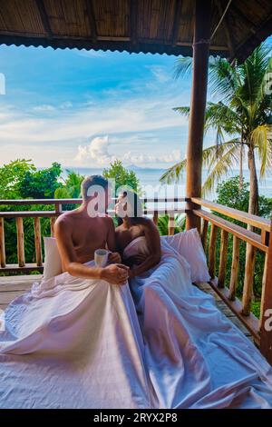 Coppia di uomini e donne sul balcone della capanna sulla spiaggia con caffè a Railay Beach Krabi Thailandia la mattina Foto Stock