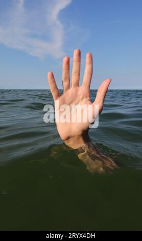 cinque dita della mano mentre annegano nell'oceano e chiedono aiuto simbolo di fallimento e fallimento Foto Stock