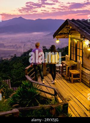 Coppia che guarda l'alba con la nebbia a Phu Langka, nel nord della Thailandia, nel parco nazionale di Phu Langka Foto Stock