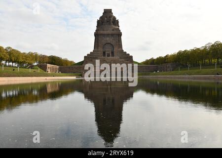 Stagno che riflette il Monumento alla Battaglia delle Nazioni a Lipsia, in Germania, contro un cielo nuvoloso Foto Stock