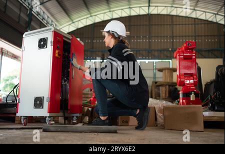 Ingegnere elettrico con la missione di installare un sistema elettrico del braccio robotizzato Foto Stock