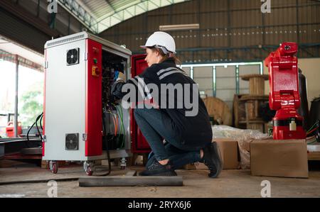 Ingegnere elettrico con la missione di installare un sistema elettrico del braccio robotizzato Foto Stock