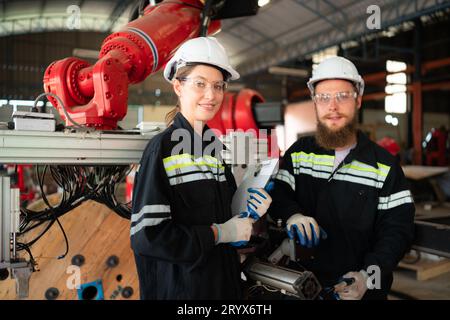 Ritratto di un ingegnere elettrico con la missione di installare un sistema elettrico del braccio robotizzato Foto Stock