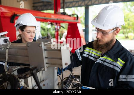 Ingegnere elettrico con la missione di installare un sistema elettrico del braccio robotizzato Foto Stock