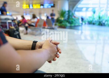 Uomo in attesa del volo nell'area di partenza dell'aeroporto in attesa del volo. Foto Stock