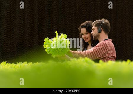 Due piccoli imprenditori proprietari di orti biologici stanno attualmente presentando i clienti e mostrando loro il suo g di verdure biologiche Foto Stock