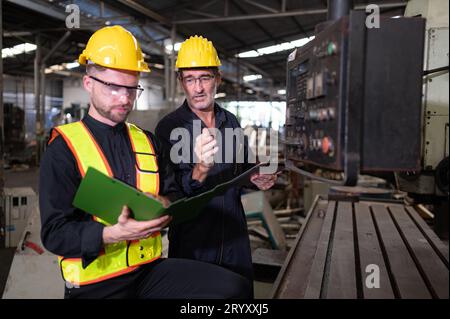 Ingegneri e tecnici ispezionano e riparano i sistemi meccanici negli armadi di controllo delle macchine. affinché la macchina ritorni Foto Stock