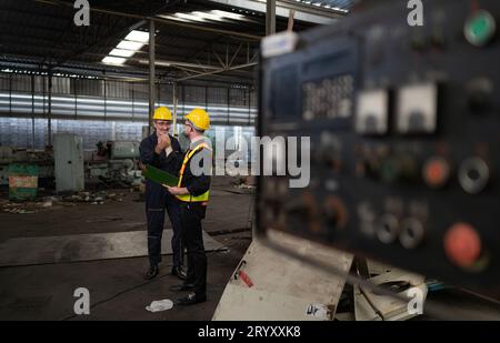 Ingegneri e tecnici ispezionano e riparano i sistemi meccanici negli armadi di controllo delle macchine. affinché la macchina ritorni Foto Stock