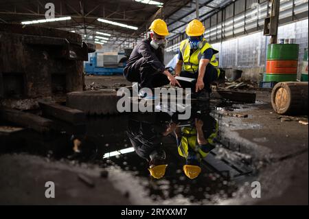 Scienziati e funzionari governativi ispezionano e raccolgono campioni di perdite chimiche nei siti industriali. da esaminare a fondo Foto Stock