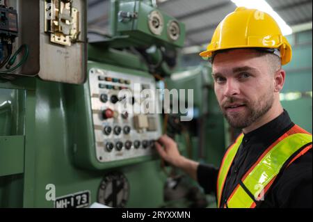 Il tecnico ispeziona l'impianto elettrico e ripara il sistema meccanico nell'armadio di controllo della macchina. in ordine per la m Foto Stock