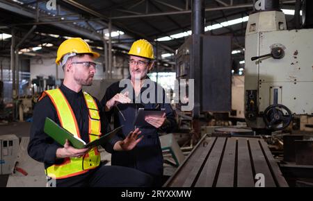 Ingegneri e tecnici ispezionano e riparano i sistemi meccanici negli armadi di controllo delle macchine. affinché la macchina ritorni Foto Stock